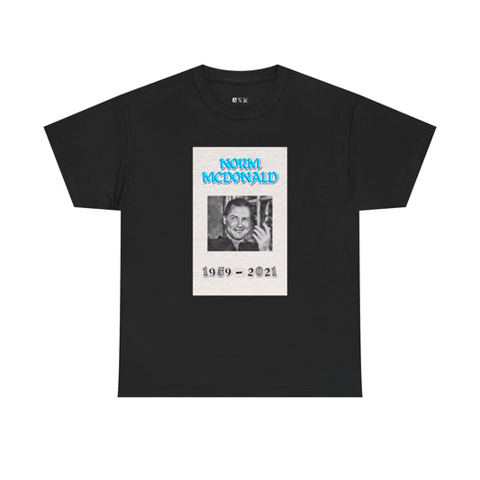 Norm McDonald black unisex heavyweight tee shirt honoring the comedy legend. It features a smiling portrait with electric blue lettering and the years 1959–2021. A timeless tribute to be enjoyed by any Norm McDonald fan.